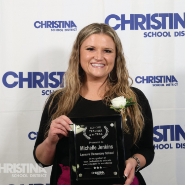 Photo of Michelle Jenkins holding 2025-2026 Teacher of the Year plague
